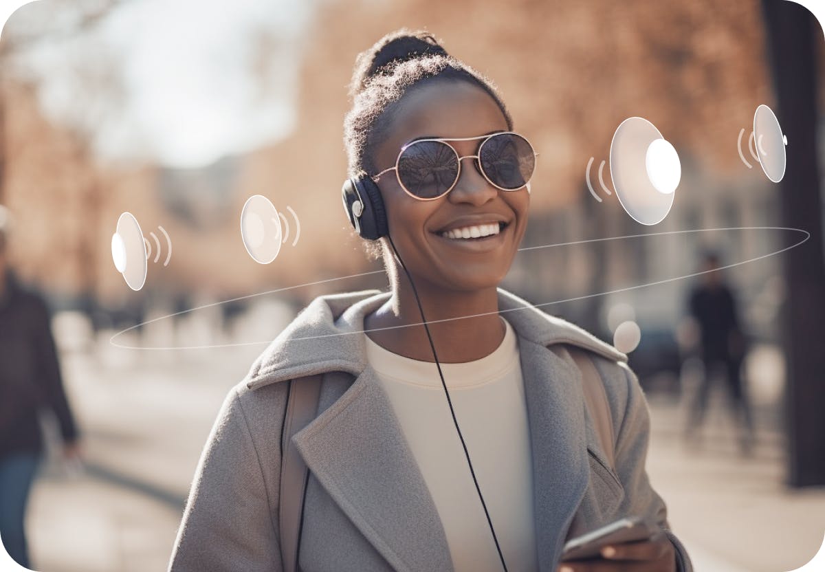 Image of a woman wearing shades and headphones walking down a busy street using Soundscape Community. With supplemental white speakers surrounding her head to show the spatial audio from the application